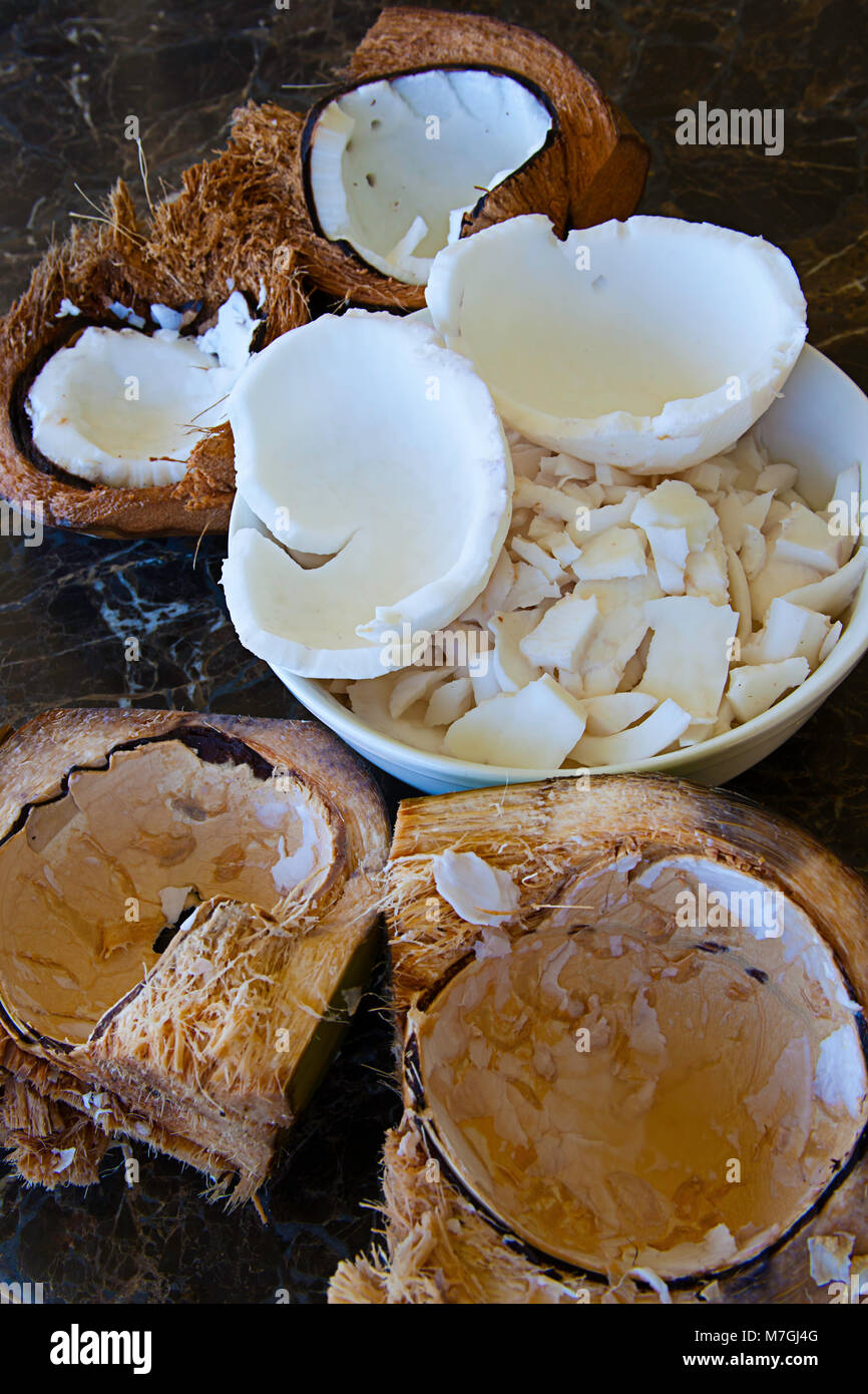 Eine Schüssel mit raw Kokosnuss in eine Schüssel und Split mit den Hülsen, Hawaii öffnen. Stockfoto