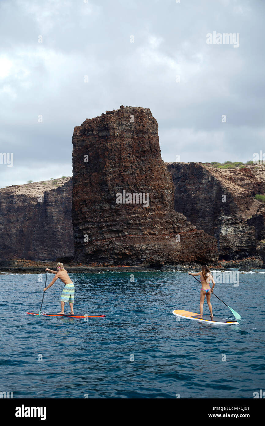 Ein junges Paar auf Stand-up Paddle Boards an Nadeln vor der Insel Lanai, Hawaii. Beide sind erhältlich. Stockfoto