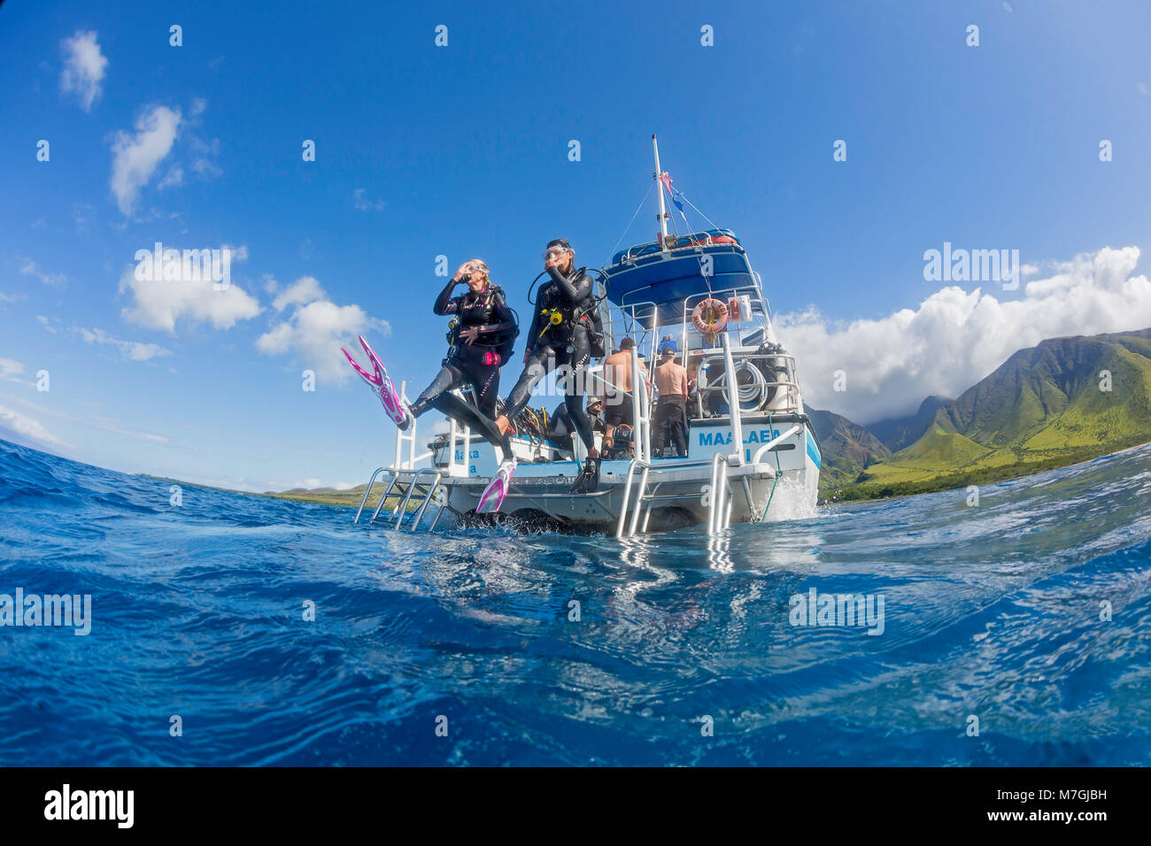 Taucher (MR) Schritt weg von einem Tauchboot in den Pazifischen Ozean aus Ukumehame, Maui, Hawaii. Stockfoto