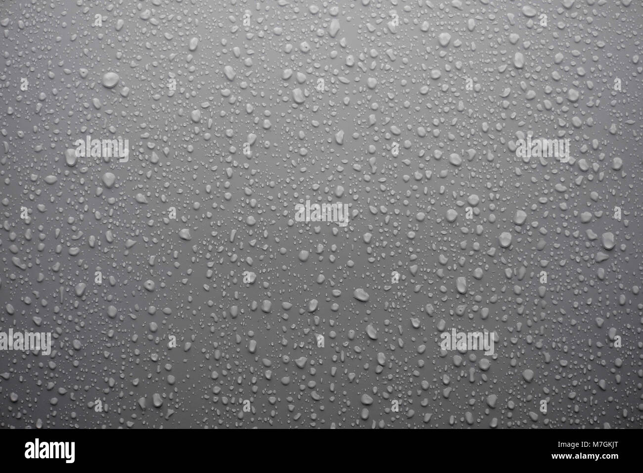 Wassertropfen auf graue Oberfläche als Hintergrund Stockfoto