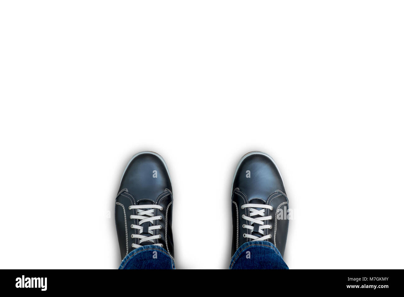 Isolierte schwarze Freizeitschuhe stehend auf dem weißen Teppich boden Stockfoto