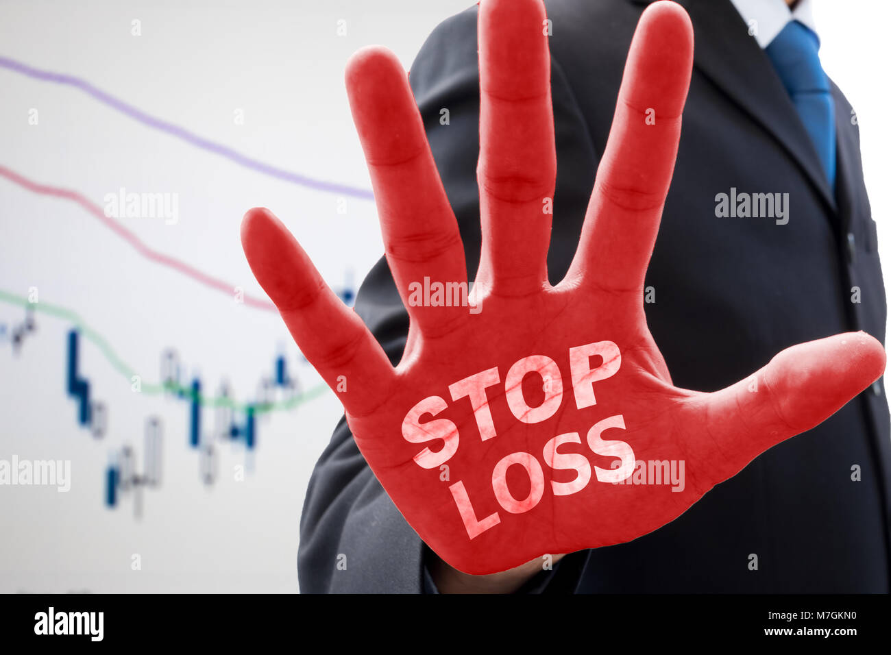 Geschäftsmann in dunklen grauen Anzug seine Hand in Aktion zu stoppen und die Worte "stop loss" auf seinem Red Palm anheben. Erklären, wie Verlust von businss Gefahr zu stoppen und Stockfoto