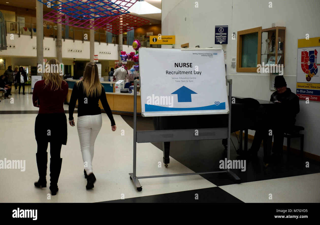 Eine Krankenschwester Rekrutierung Zeichen ist neben einem Pianisten in der Haupteingang des Queen's Krankenhaus in Romford angezeigt, in East London am 10. März 2018. Stockfoto