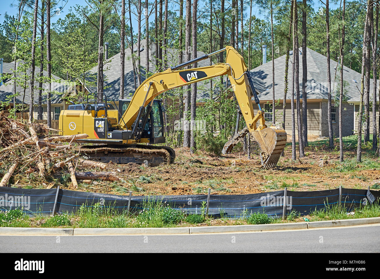 Digger oder Bagger clearing Land für den Bau neuer Gebäude in Hecht Straße Alabama, USA. Stockfoto