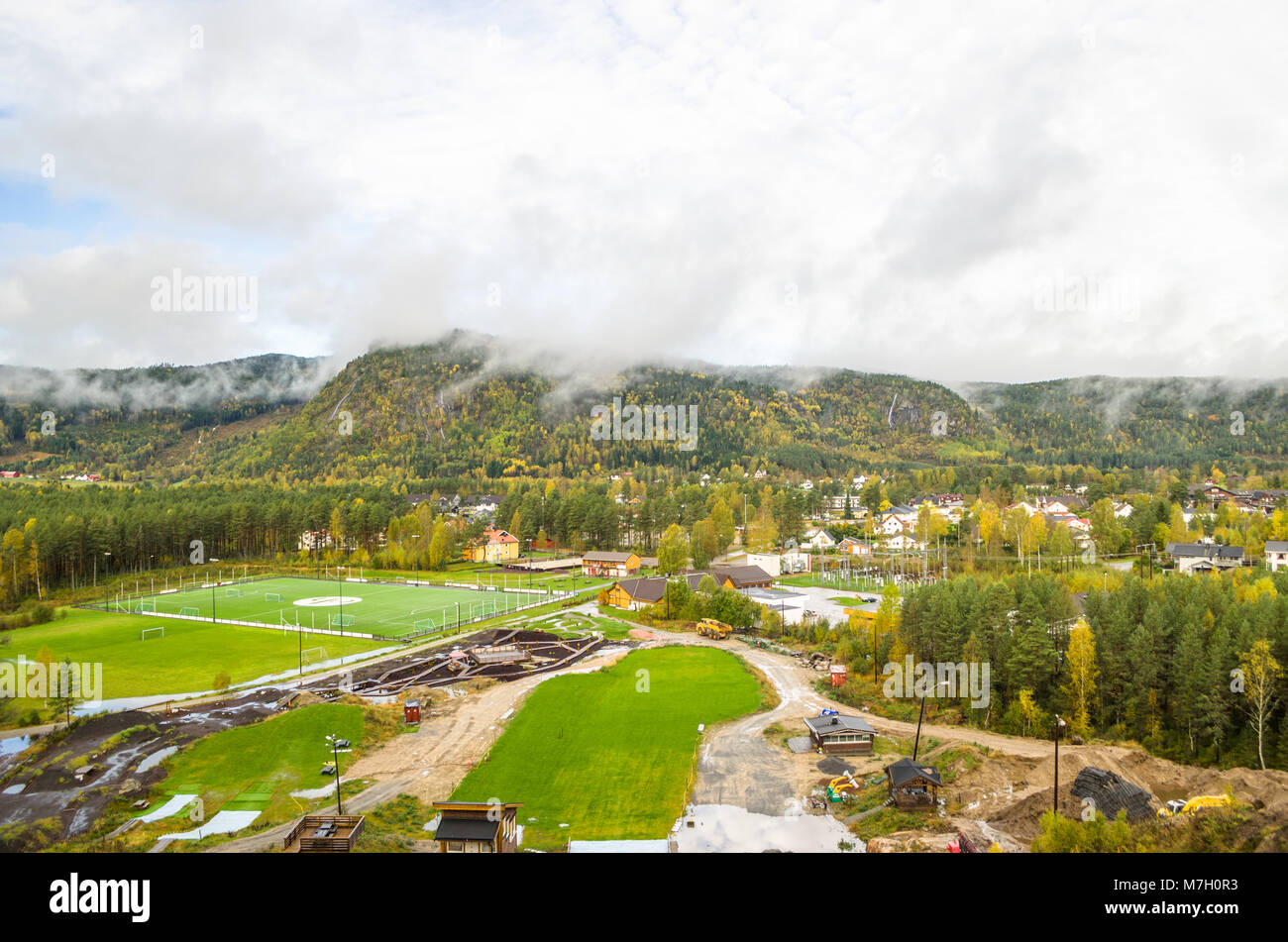 Breites Panorama von Cityline von Evje, Zentrales Norwegen mit lokalen Sport Center im Vordergrund. Stockfoto