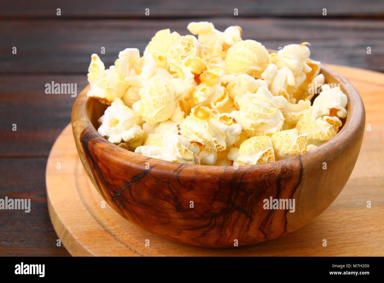 Gesalzene Popcorn in eine hölzerne Schüssel auf einen hölzernen Tisch Stockfoto