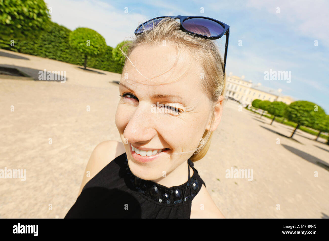 Nahaufnahme von Glücklich lächelnde junge Frau Blinken ein Auge Stockfoto