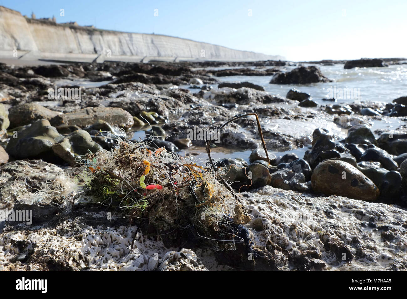 Angelschnur und Gewichte zwischen den Felsen in der Nähe von Brighton Marina. Strand Müll gewaschen an Land Stockfoto