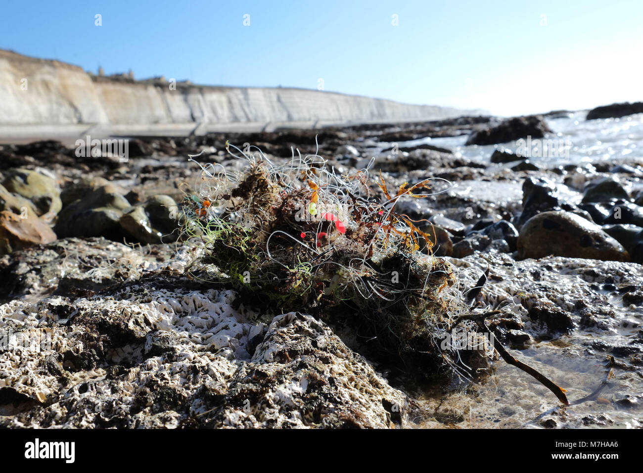Angelschnur und Gewichte zwischen den Felsen in der Nähe von Brighton Marina. Strand Müll gewaschen an Land Stockfoto