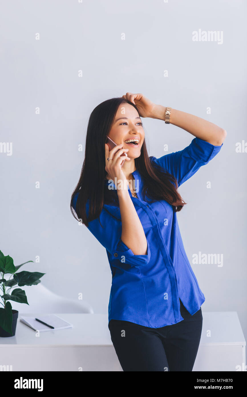 Attraktive latin modern Lady emotional am Telefon zu sprechen und zu lachen. Interaktive Unterhaltung Stockfoto
