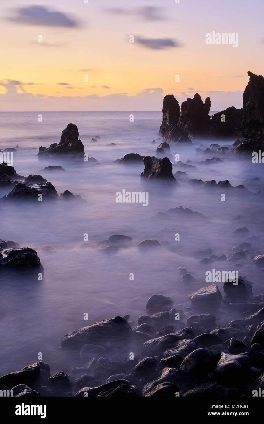 Lava Felsformationen auf Playa de la Montana Bermeja Strand, in der Nähe von El Golfo, Lanzarote. Kanarische Inseln, Spanien. Lange Exposition bei Sonnenuntergang. Stockfoto