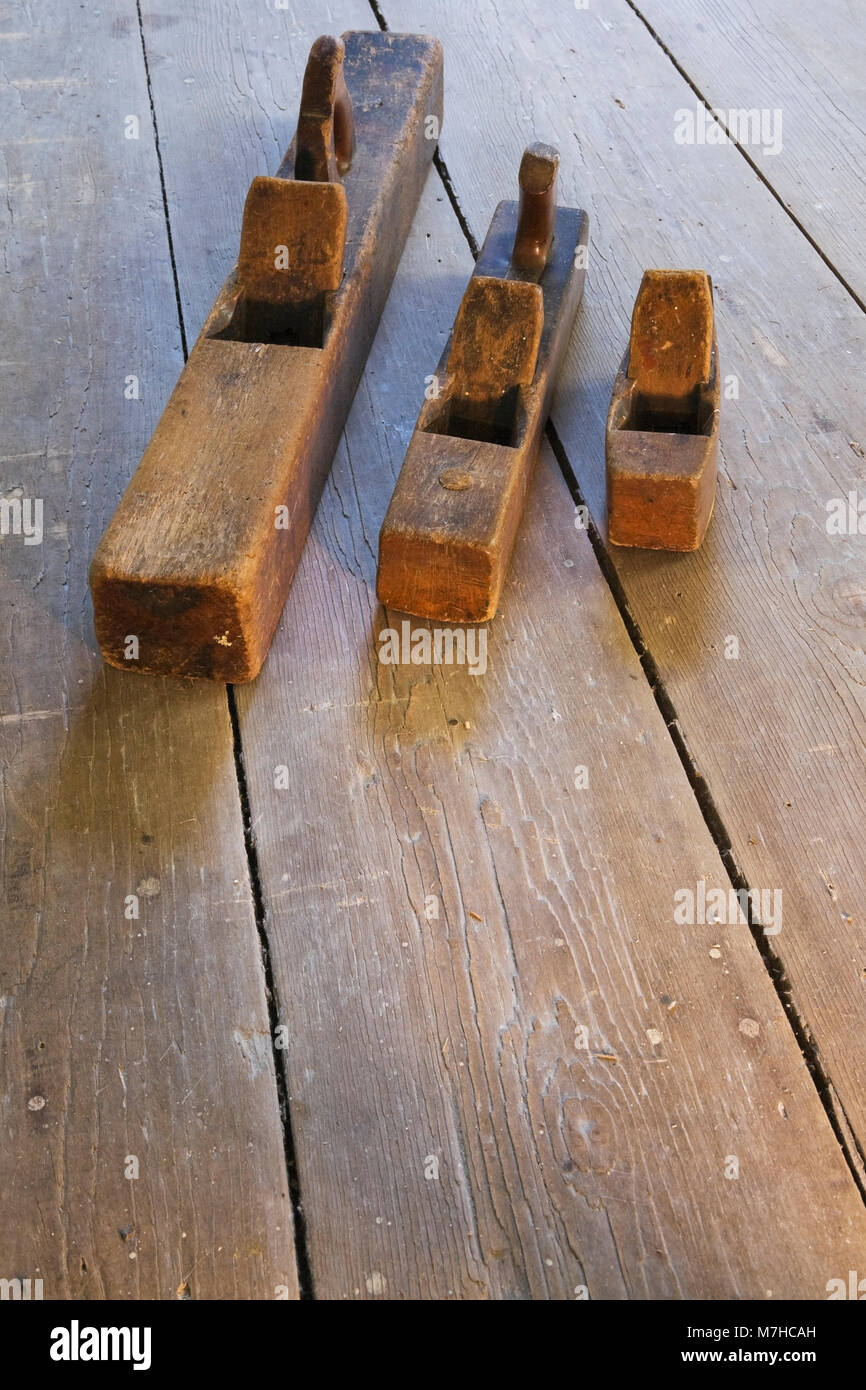 Alte hölzerne Hand Flugzeuge auf Holzboden in leeren Raum innerhalb eines alten 1800s Cottage style Home. Stockfoto