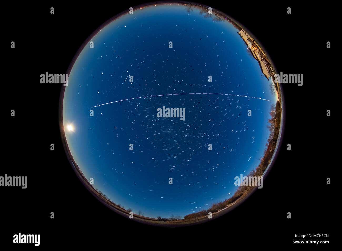 Ein overhead Pass von der Internationalen Raumstation mit dem Vollmond im Osten. Stockfoto