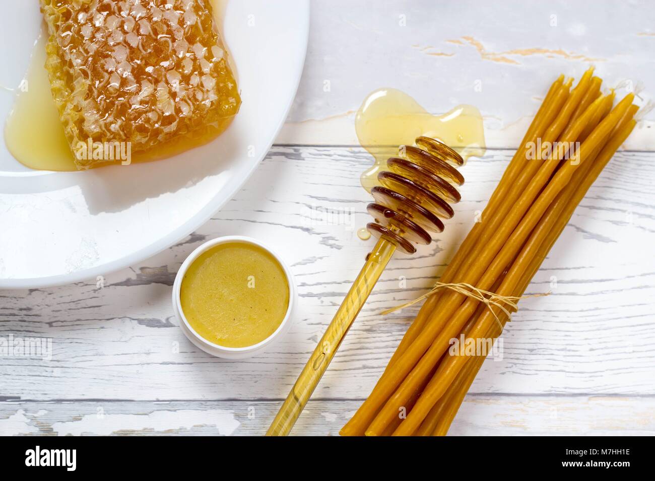 Bio Honig, honig Lippenbalsam und natürlichen Wachs Kerzen auf hölzernen weißen Hintergrund Stockfoto