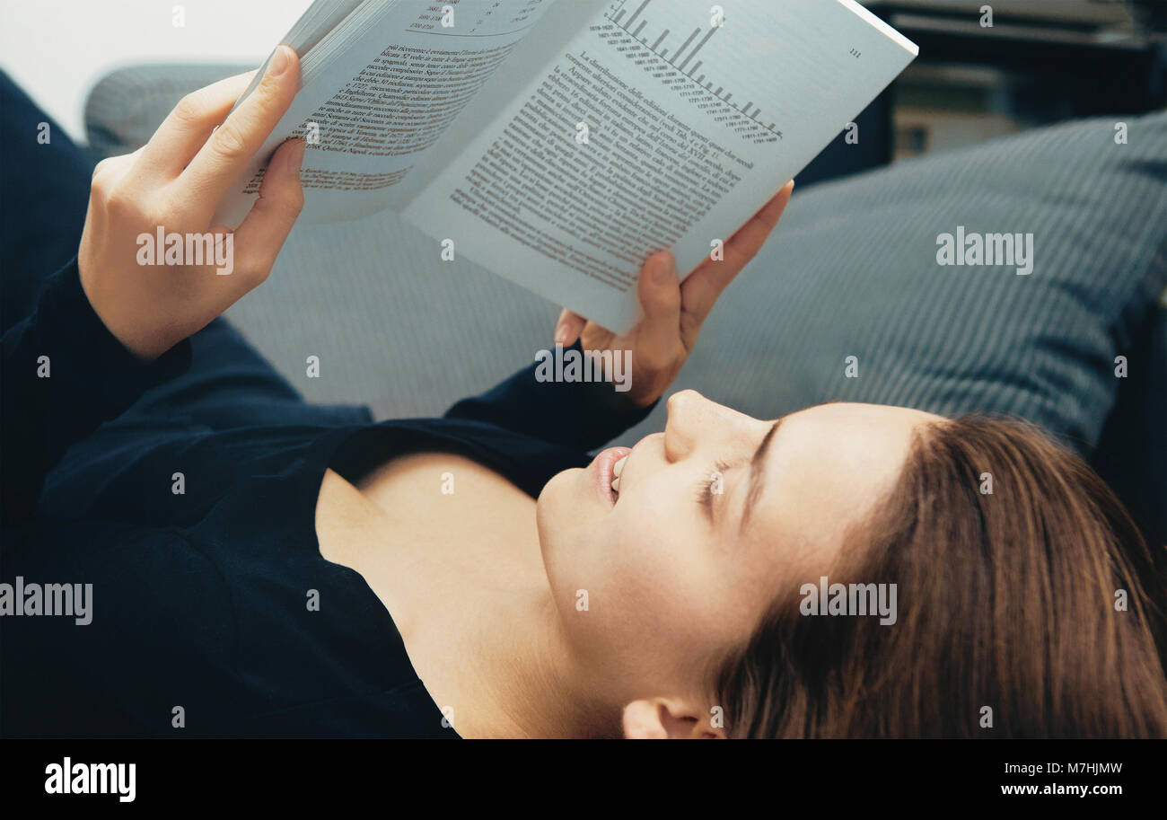 Frau auf Sofa mit Buch, entspannen Stockfoto
