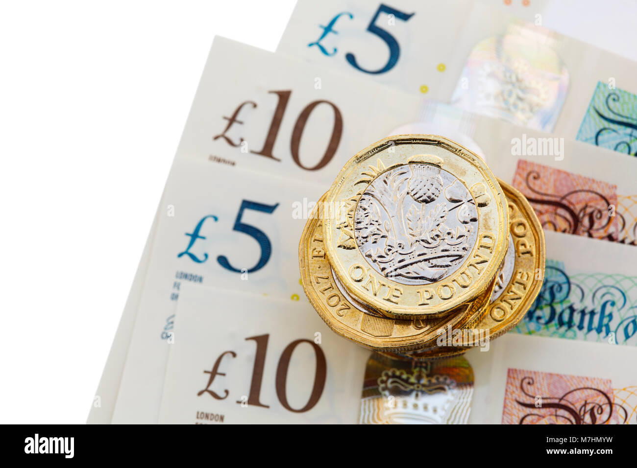 Stapel von neuen 12-seitigen englischen ein-Pfund-Münzen £ Pfund Sterling uk Geld Bargeld auf neue Polymer-Kunststoff £10 und £5 Banknoten GBP close-up. England Großbritannien Stockfoto