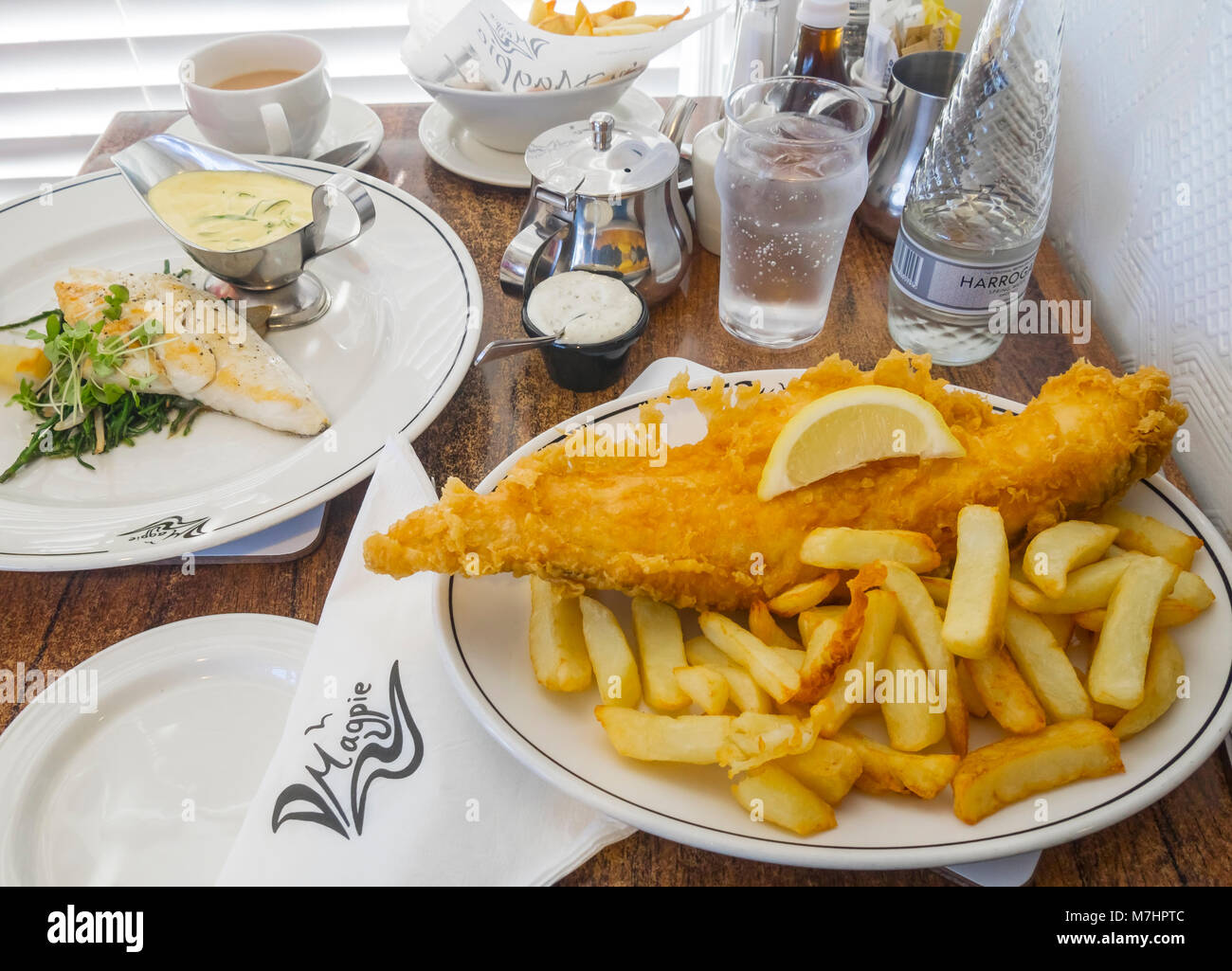 Mittagessen für zwei an der berühmten Magpie Café in Whitby, North Yorkshire England UK ein gebratener Schellfisch und Chips und der Seehecht mit Queller und Sauce Béarnaise Stockfoto