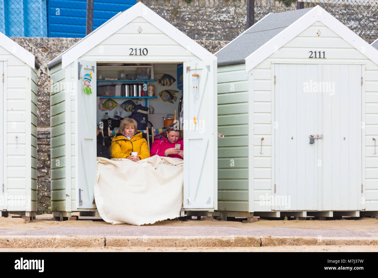 Bournemouth, Dorset, Großbritannien. 11. März, 2018. Muttertag am Strand von Bournemouth auf einem grauen bewölkten Tag - Zuflucht in der Strandhütte. Credit: Carolyn Jenkins/Alamy leben Nachrichten Stockfoto