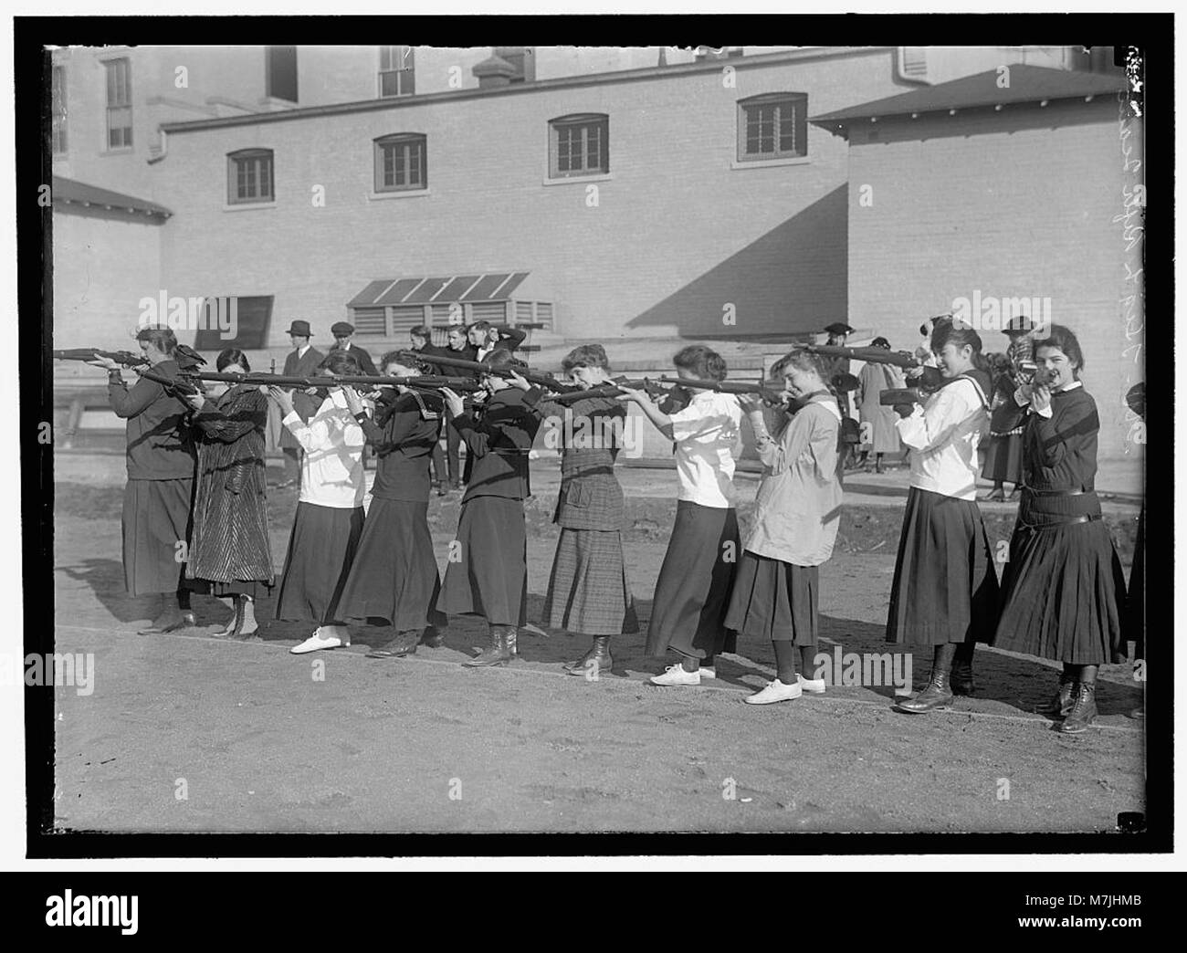 Ein Foto von Mädchen an der Western High School, die an der Gewehrausbildung teilnehmen und die Rolle der Schule bei der Förderung von Sportunterricht und außerschulischen Aktivitäten hervorheben. Stockfoto