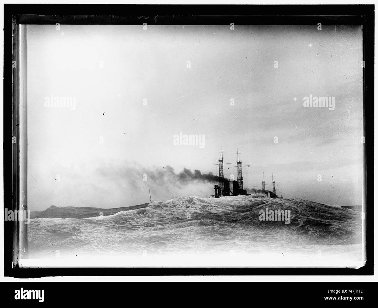 Ein dramatisches Foto, das US-Schlachtschiffe zeigt, die durch einen mächtigen Sturm auf See kämpfen, und zeigt die Stärke und Widerstandsfähigkeit von Marineschiffen unter schwierigen Bedingungen. Stockfoto