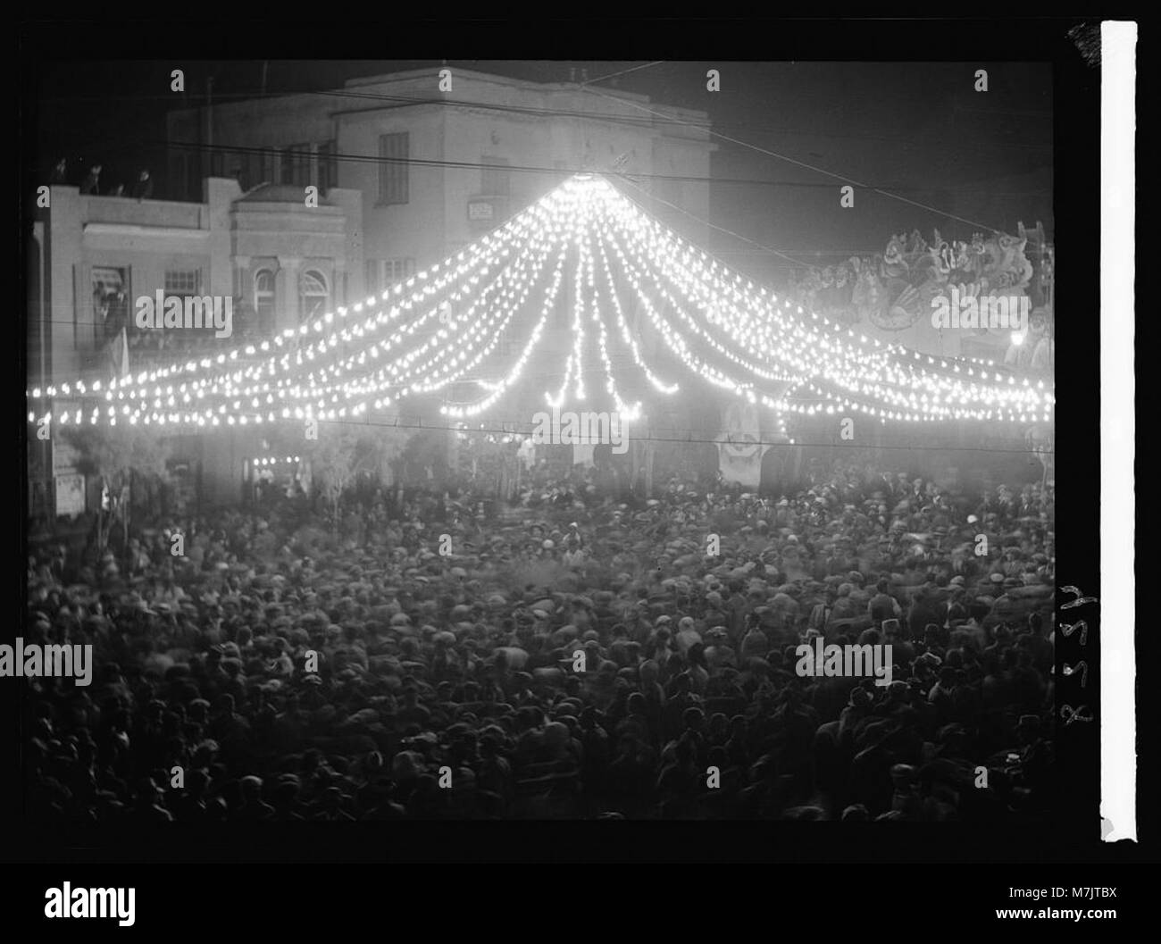 Purim Karneval in Tel Aviv. 1934. Purim Feier in Tel Aviv. Nacht Massen unter einer Überdachung der Lichter LOC 15802 matpc. Stockfoto