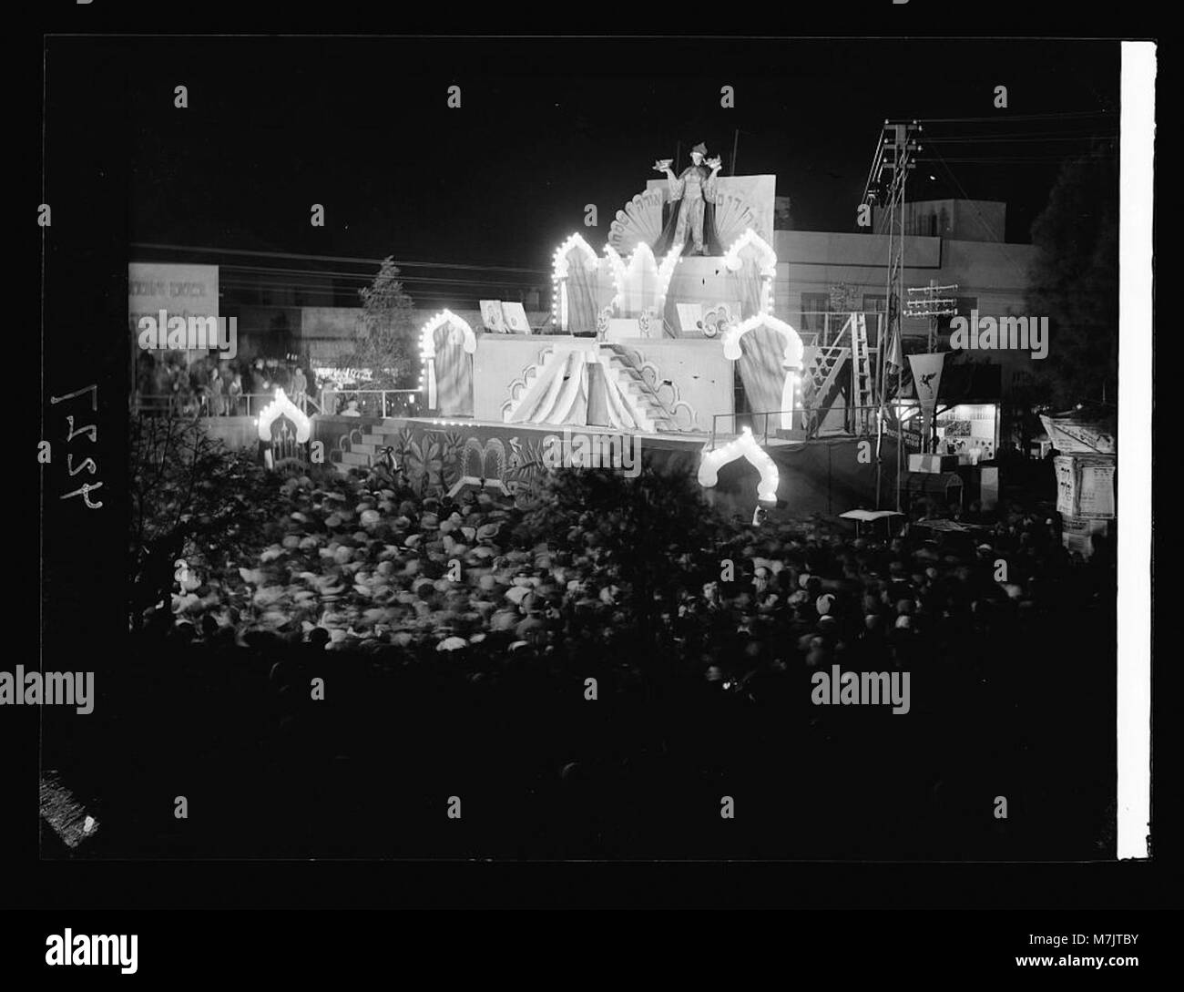Ein nächtliches Foto des Purim Karnevals in Tel Aviv, aufgenommen 1934, das Menschenmassen auf dem Stadtplatz zeigt, die das jüdische fest von Purim feiern. Stockfoto