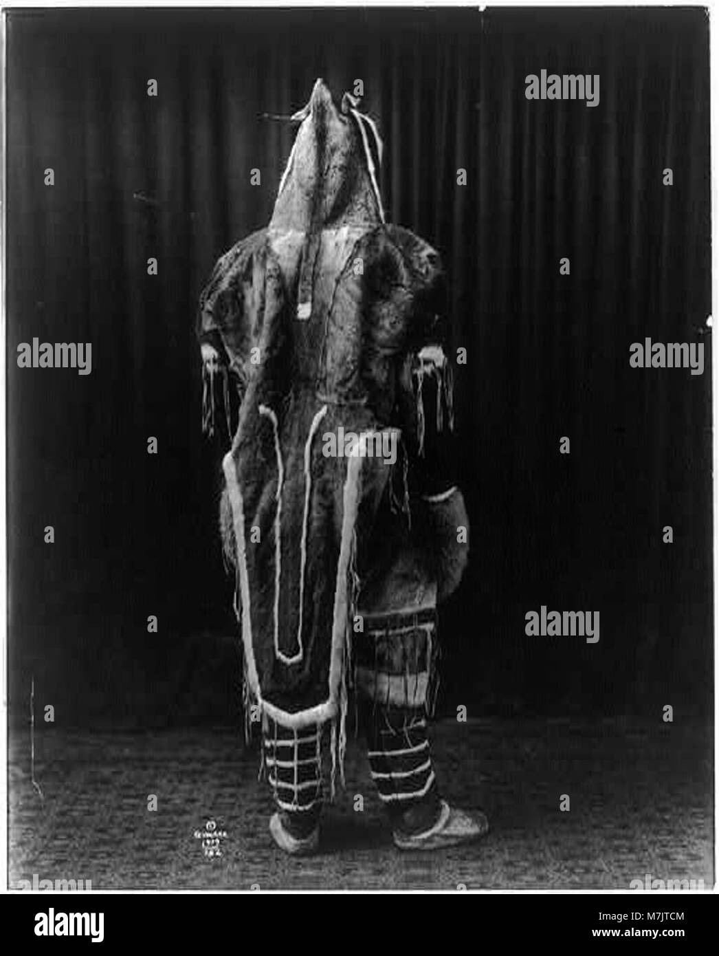 Eine Rückansicht einer Person, die ein traditionelles Eskimo-Kostüm trägt und kulturelle Kleidung und Bräuche der einheimischen arktischen Gemeinschaften darstellt. Dieses Foto zeigt das Design des Kleidungsstücks und seine kulturelle Bedeutung. Stockfoto