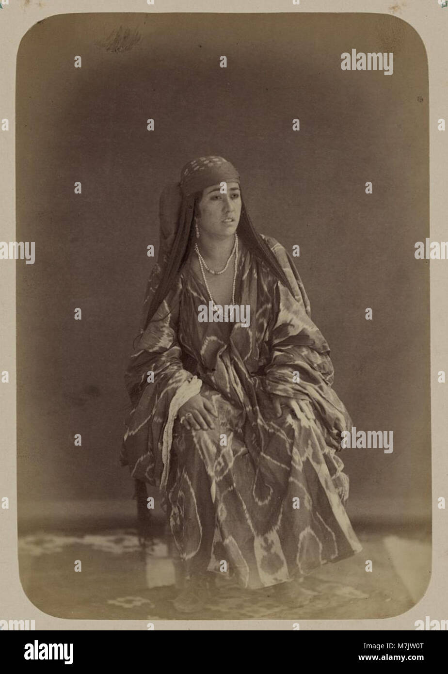 Eine Fotografie einer traditionellen usbekischen Frau aus Turkestan, die sie in typischer Kleidung zeigt und die kulturelle und ethnische Vielfalt Zentralasiens im frühen 20. Jahrhundert hervorhebt. Stockfoto