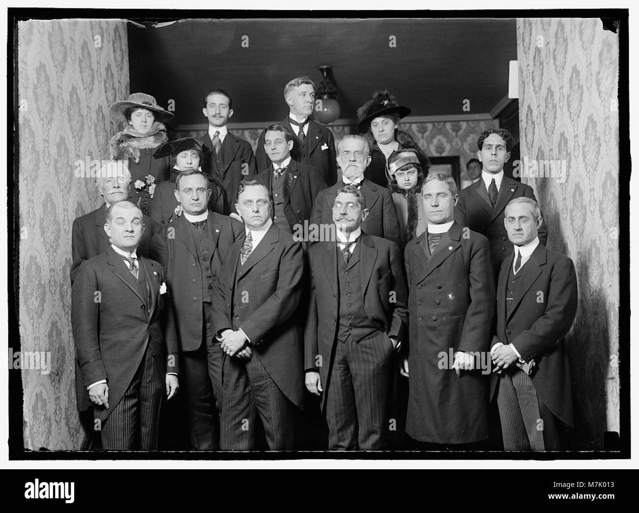 Ein Bild von John Barrett, Generaldirektor der Pan American Union von 1907 bis 1920, mit einer nicht identifizierten Gruppe von 12 Männern, 3 Frauen und einem Kind am Eingang seines Wohnhauses. Stockfoto