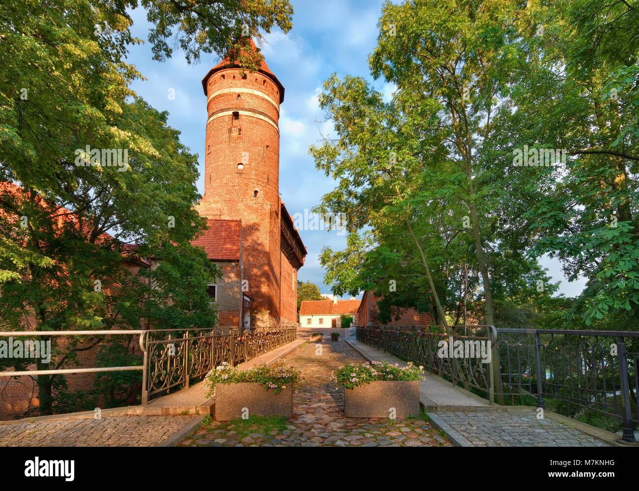 Brücke mit Liebe Vorhängeschlösser über Fluss Lyna, gotische Burg des Fürstbistums Ermland im Hintergrund, Olsztyn, Polen Stockfoto