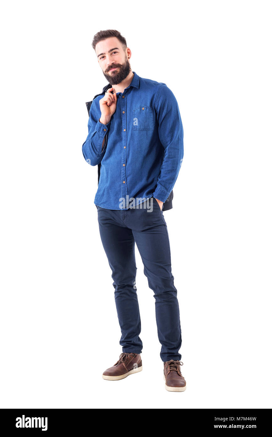 Gerne entspannt lächelnd Mann in Blue Denim t-shirt die Jacke über die Schulter auf Kamera schaut. Voller Körper auf weißem Hintergrund. Stockfoto