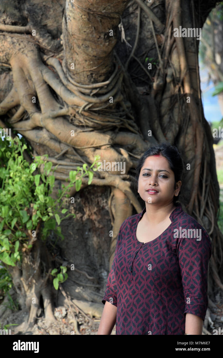 Schöne Bengali Mädchen steht vor einem großen Baum im Freien Stockfoto