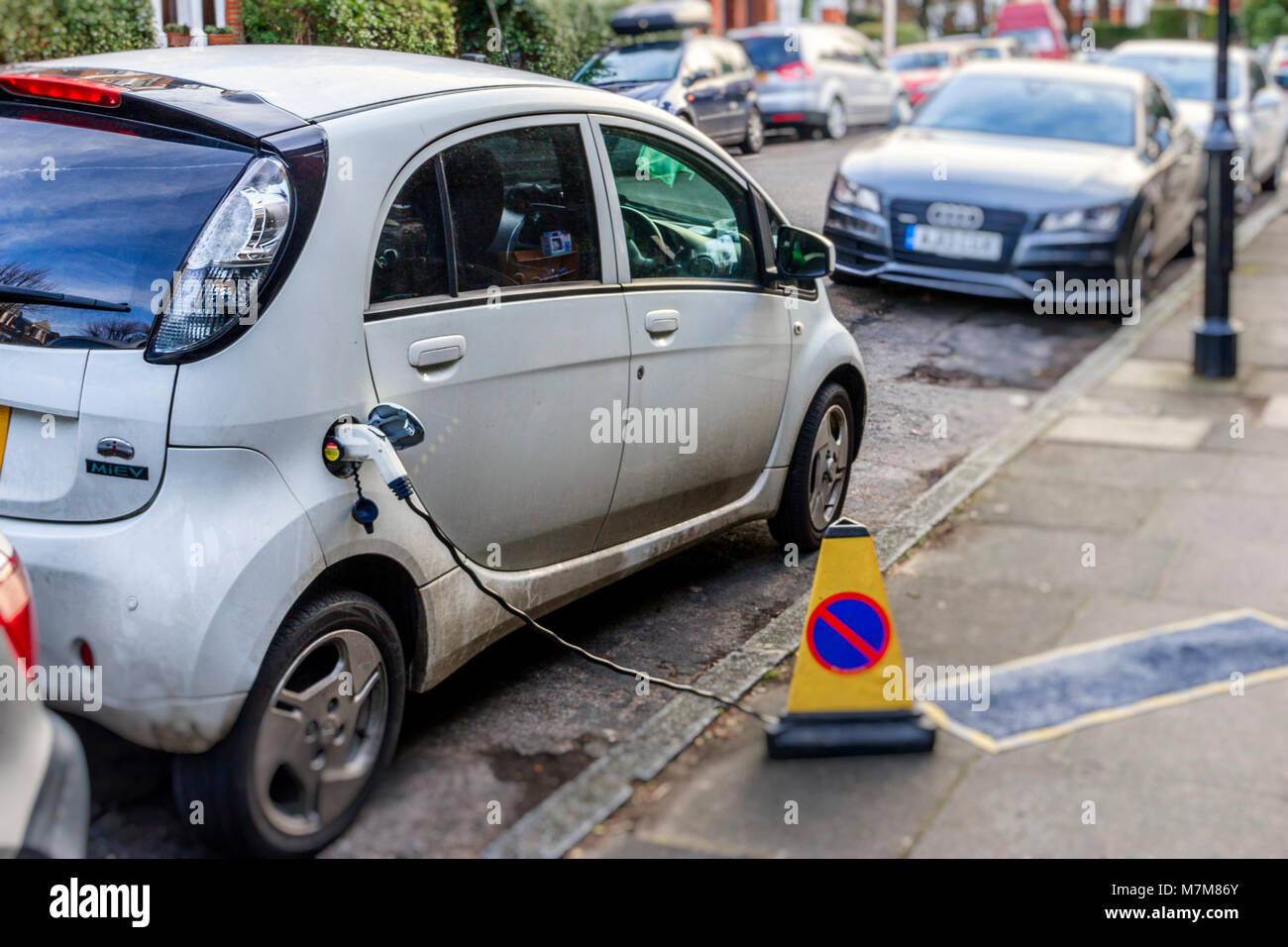 Eine elektrisch angetriebene Auto am Straßenrand in einem Wohnviertel im Norden Londons geladen wird, Großbritannien Stockfoto