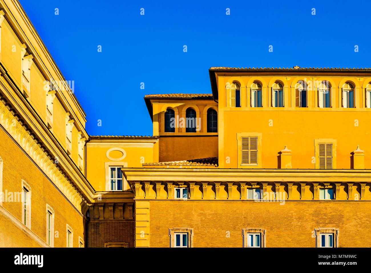 Die Außenfassade des typisch römischen Palazzo Stil mit orange Farben gegen den blauen Himmel Hintergrund Stockfoto