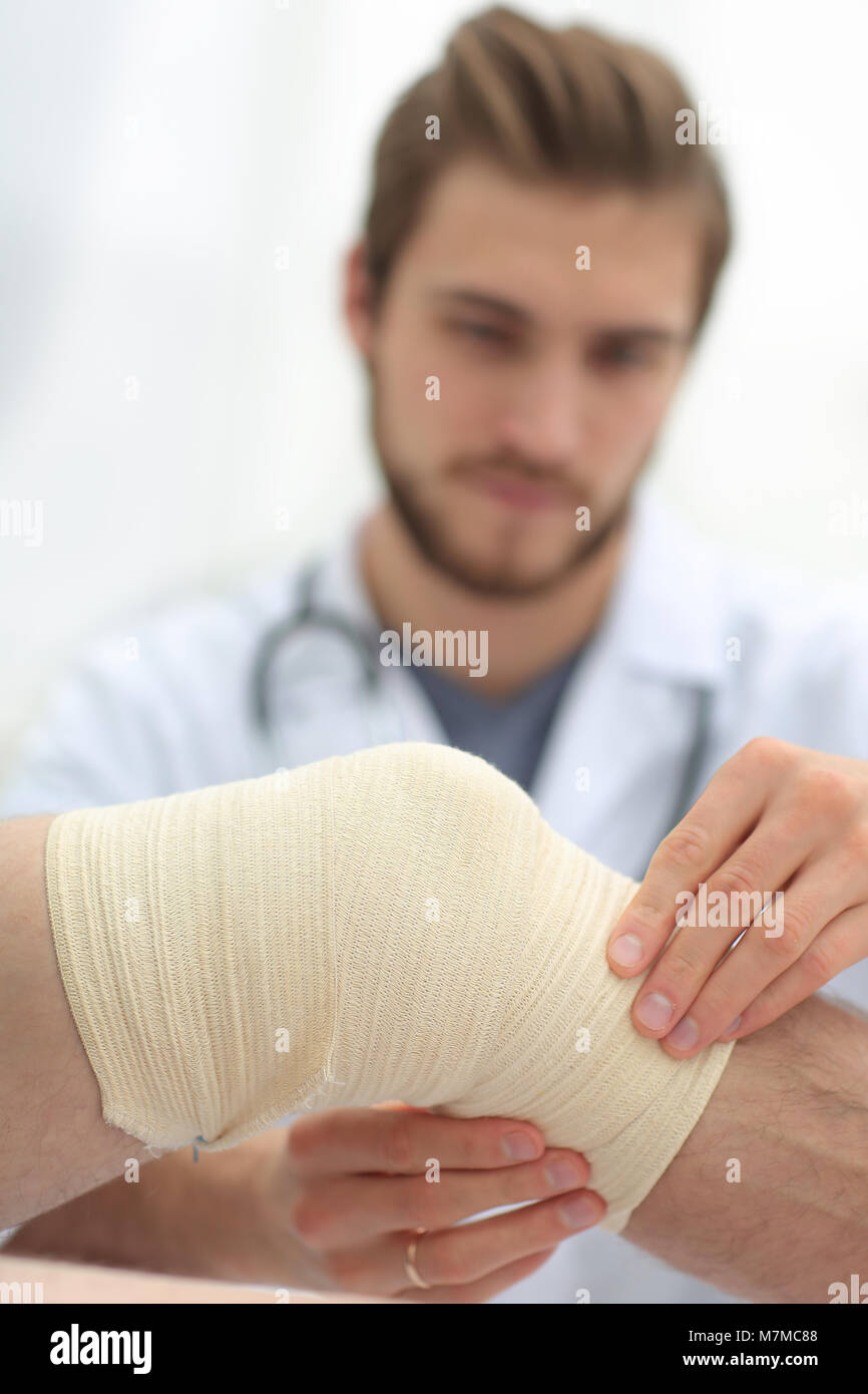 Traumatologist Prüfung der Verband auf seinem Knie Stockfotografie Alamy