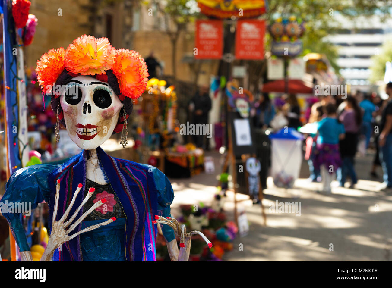 Skelett Puppe lackiert und mit orange Papiermache Blumen und Ohrringe für Dia de los Muertos/Tag der Toten eingerichtet Stockfoto