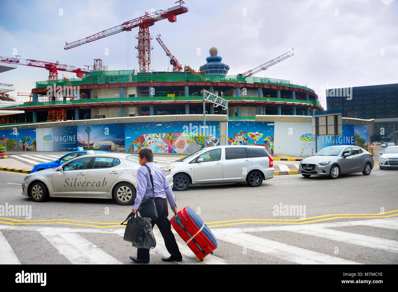 Singapur - Jan 13, 2017: Mann Tragetasche vor der Baustelle des Changi Airport Terminal. Changi Airport dient mehr als 100 Airlines Stockfoto