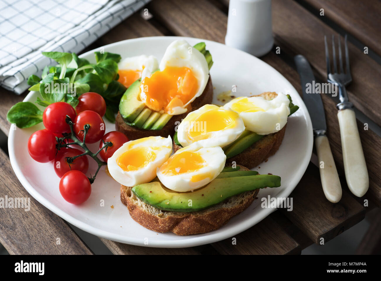 Ei und Avocado, grüner Salat und Kirschtomaten auf weiße Platte. Gesundes Frühstück, gesunde Lebensweise, vegan, vegetarisch oder Gewichtsverlust Konzept Stockfoto