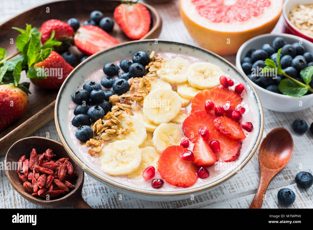 Smoothie Schüssel mit Erdbeeren, Banane, Heidelbeeren, Granatapfel und Kokosraspeln, Detailansicht. Konzept der gesunden Lebensweise, gesunde Ernährung, vegan, v Stockfoto