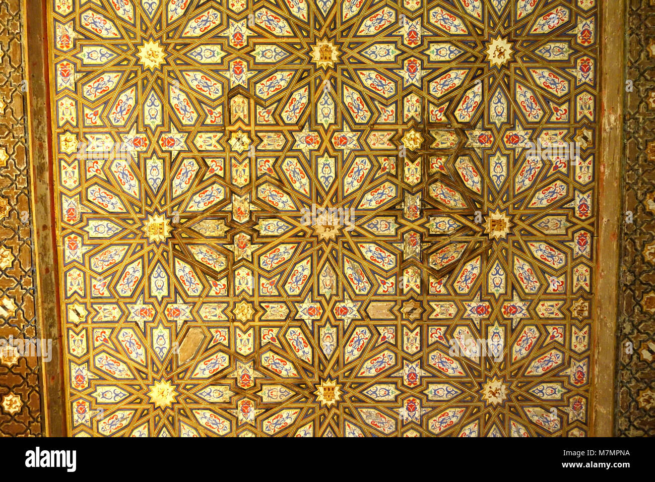 Die Decke in der Alcázar von Sevilla ist ein Paradebeispiel für Mudéjar-Kunst, die islamische, christliche und jüdische Designelemente kombiniert und die kulturelle und architektonische Synthese des mittelalterlichen Spaniens repräsentiert. Stockfoto
