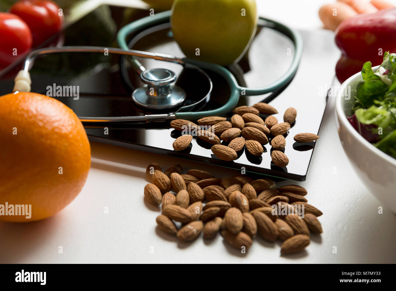 Gesundes Obst, Gemüse und Stethoskop auf Skalen. Gewicht Verlust und richtige Ernährung Konzept Stockfoto