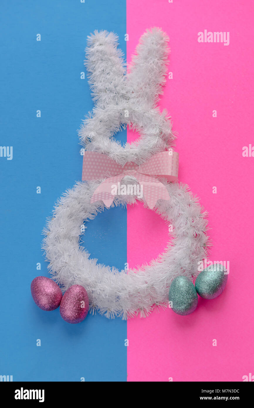 Ostern Dekorationen auf helle Farben. Weißer Draht bunny auf Rosa und blauen Hintergrund mit Polka Dot Bow Tie. Stockfoto