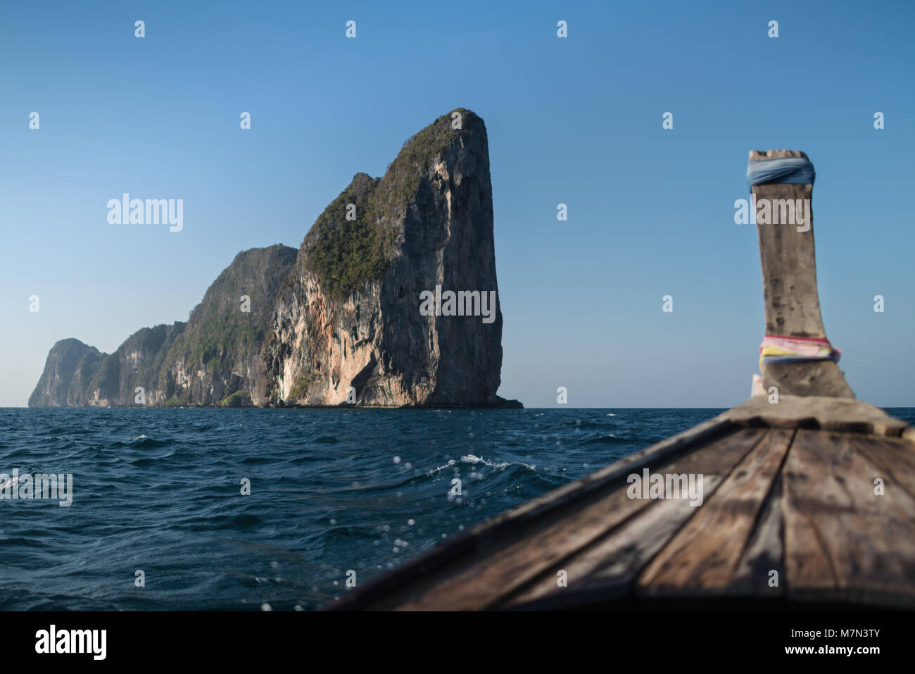 Reiseziele in Asien. Long tail Boot segelt im Meer in der Nähe von Felsen und Hügel von phi-phi Island. Nationale nautische Schiff von Thailand. Sicht nach vorne Stockfoto