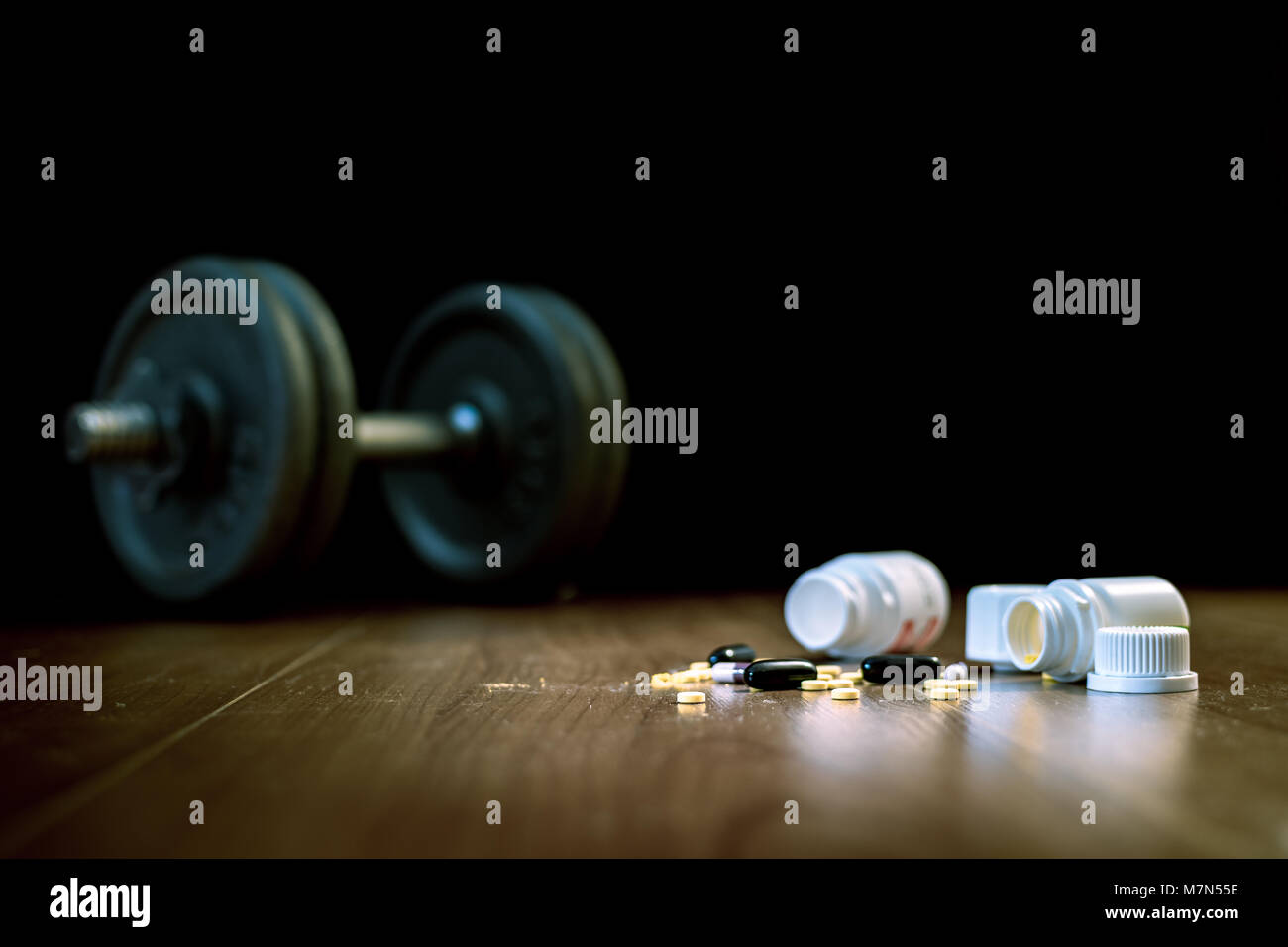 Steroid Pillen und Kapseln mit hantel Gewicht im Hintergrund - Doping im Sport. Stockfoto