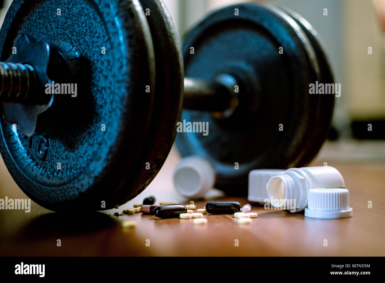 Steroid Pillen und Kapseln mit hantel Gewicht im Hintergrund - Doping im Sport. Stockfoto