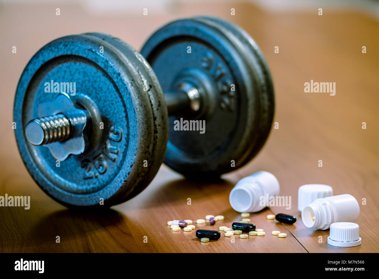 Steroid Pillen und Kapseln mit hantel Gewicht im Hintergrund - Doping im Sport. Stockfoto