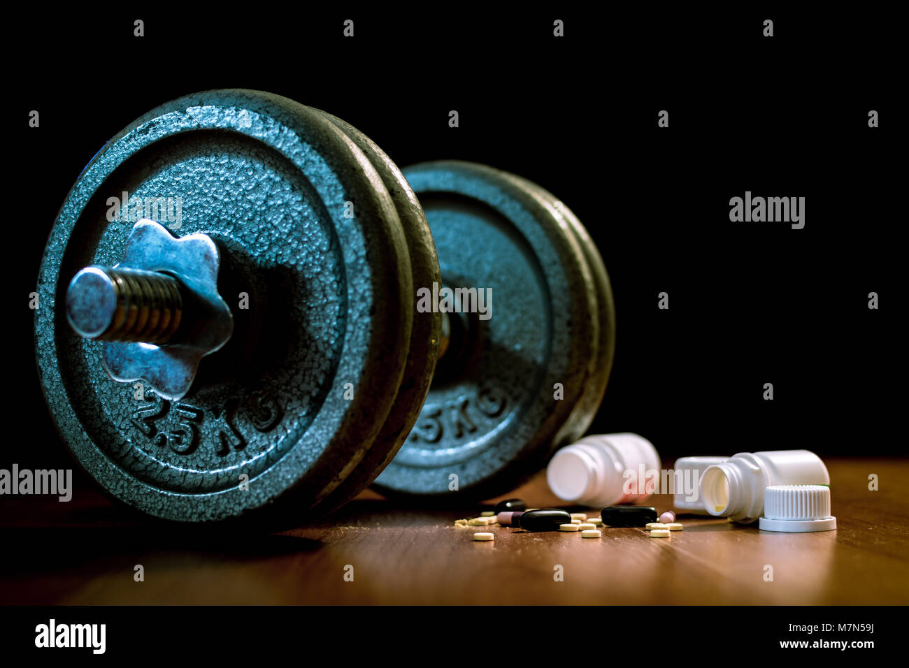 Steroid Pillen und Kapseln mit hantel Gewicht im Hintergrund - Doping im Sport. Stockfoto