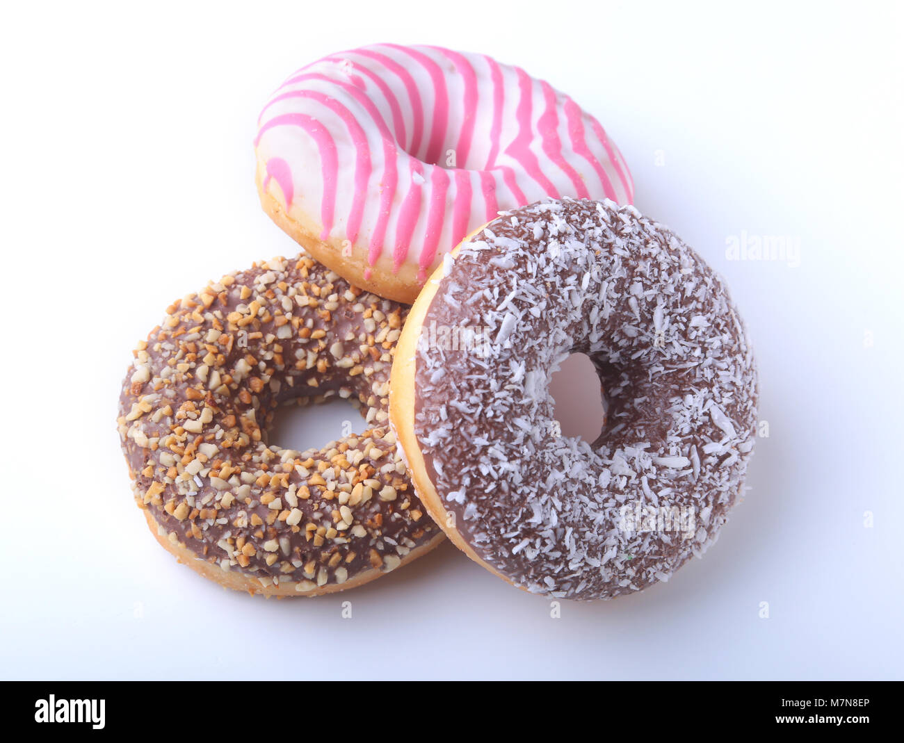 Sortierte Donuts in der Glasur, bunten Streuseln und Muttern auf weißem Hintergrund