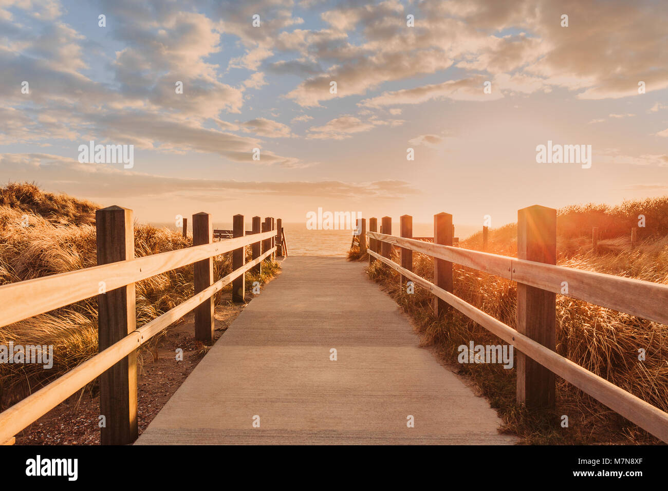 Hölzerne Seebrücke mit Blick auf das Meer bei Sonnenuntergang Stockfoto