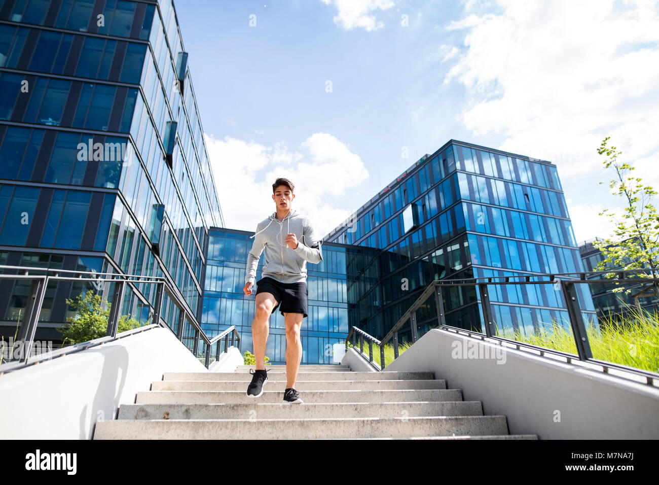 Junge Athlet läuft vor Glas Gebäude. Stockfoto